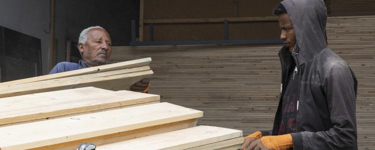 Two men loading timber onto a truck. Foto: @ Camilla Zilo