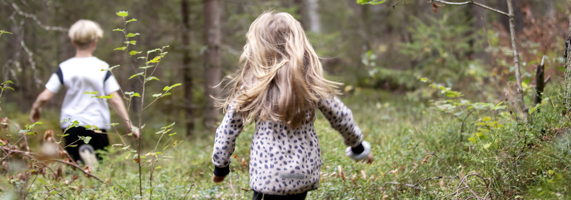Två barn som springer i skogen.  Foto: @ Camilla Zilo
