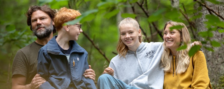 Nöjd familj sitter i skogen.  Foto: @ Camilla Zilo