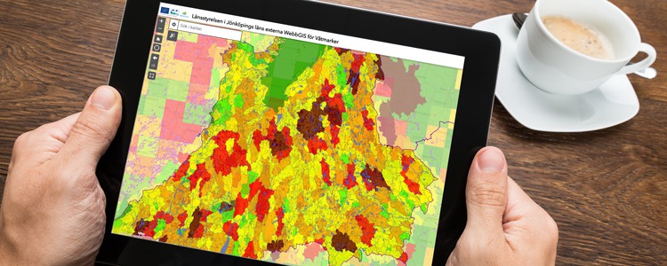 Närbild på en läsplatta. Någon håller plattan i båda händerna. På skärmen visas en karta. Foto: Mostphotos