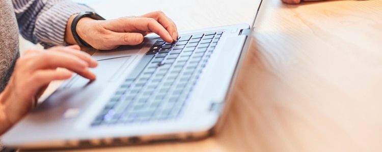 Närbild på händer som skriver på ett tangentbord till en bärbar dator. Foto: Sara Landstedt