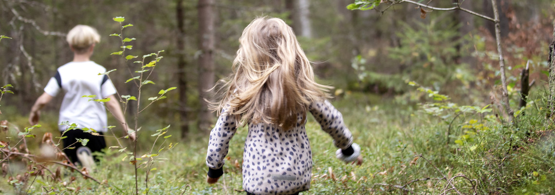 Två barn som springer i skogen.  Foto: @ Camilla Zilo