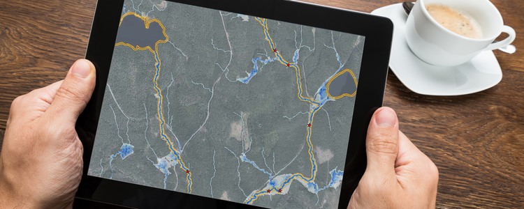 En kartbild på en surfplatta. Kartbilden visar 10 meter breda kantzoner och svämplan för bäckar i ett område. Foto: Mostphotos, montage