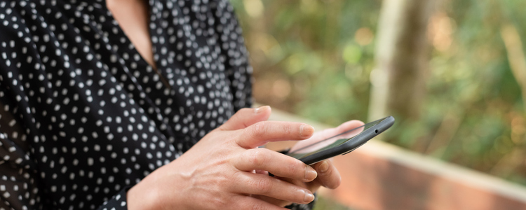 kvinna som använder en mobiltelefon utomhus. Foto: MostPhotos